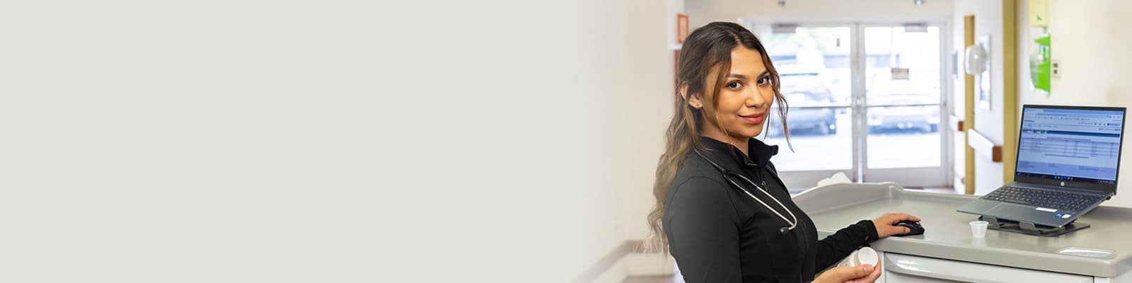 A woman sitting at a computer at San Jacinto Valley